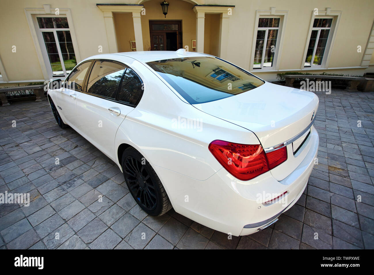 Grodno, Bielorussia, 16 Maggio 2013: il lusso moderno BMW 750Li XDrive macchina tre-quarto superiore vista ampia parcheggiato sul lastricato in pietra parcheggio vicino casa antica. Foto Stock