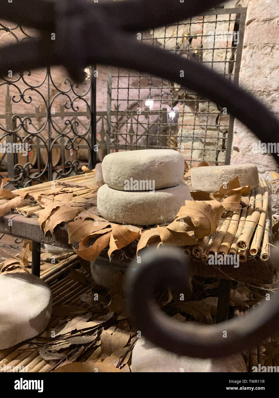 La stagionatura dei formaggi in un italiano antica cantina in pietra. Foto Stock