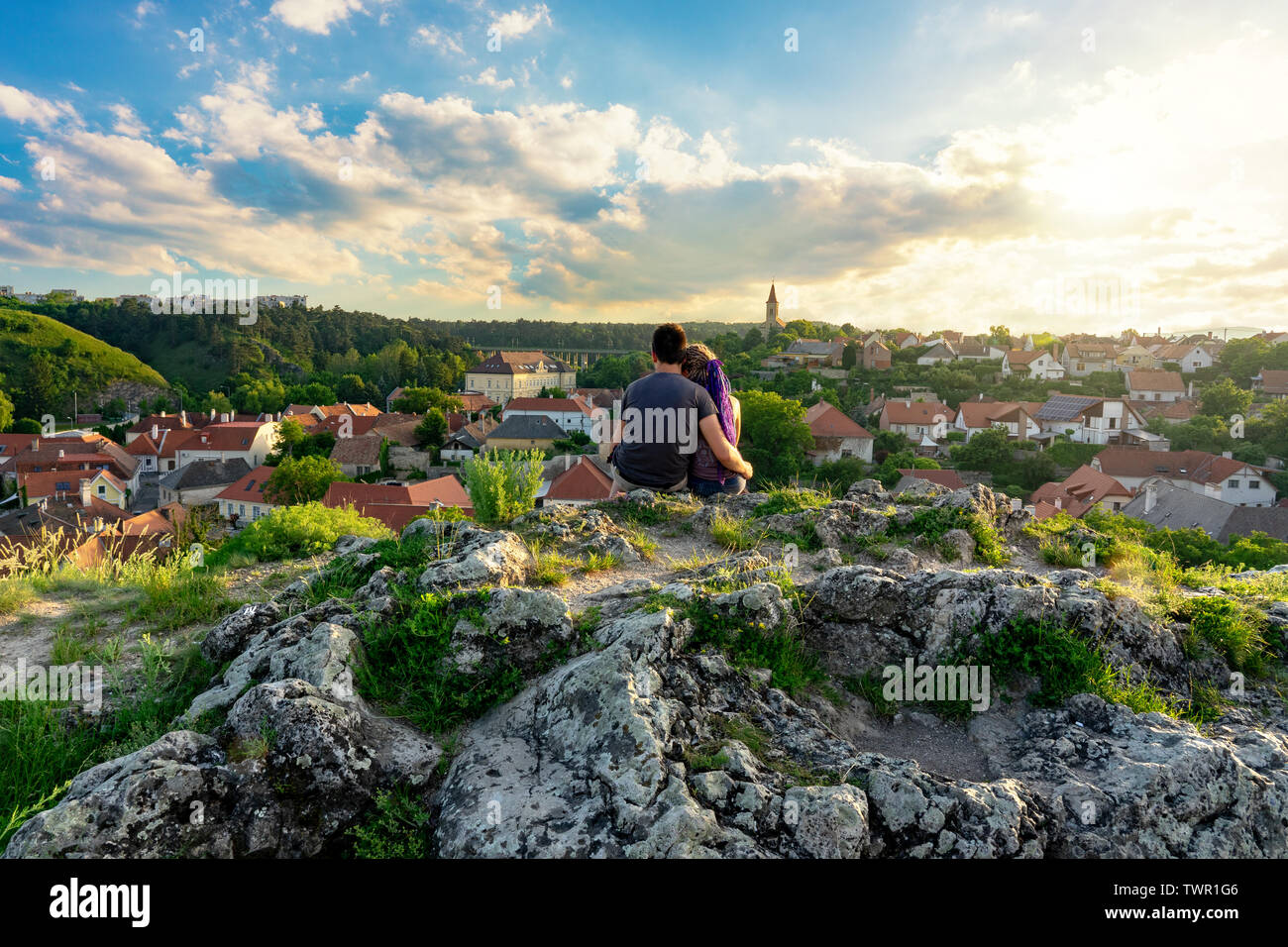 La collina giardino nel centro della città vecchia di Veszprem, Ungheria con un giovane seduto sopra la città sulla rupe godendo del tramonto romantico Foto Stock