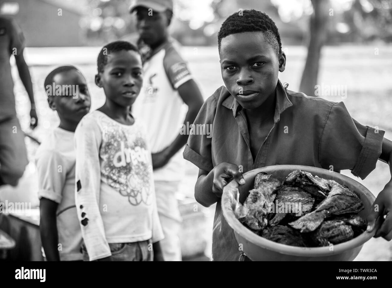 Bambino venditori ambulanti che vendono i loro pesci Chambo Foto Stock