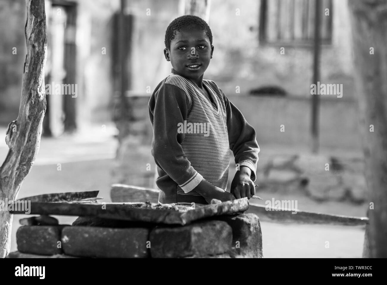 Un bambino venditore ambulante in piedi dal suo friggitrice in attesa per i clienti Foto Stock