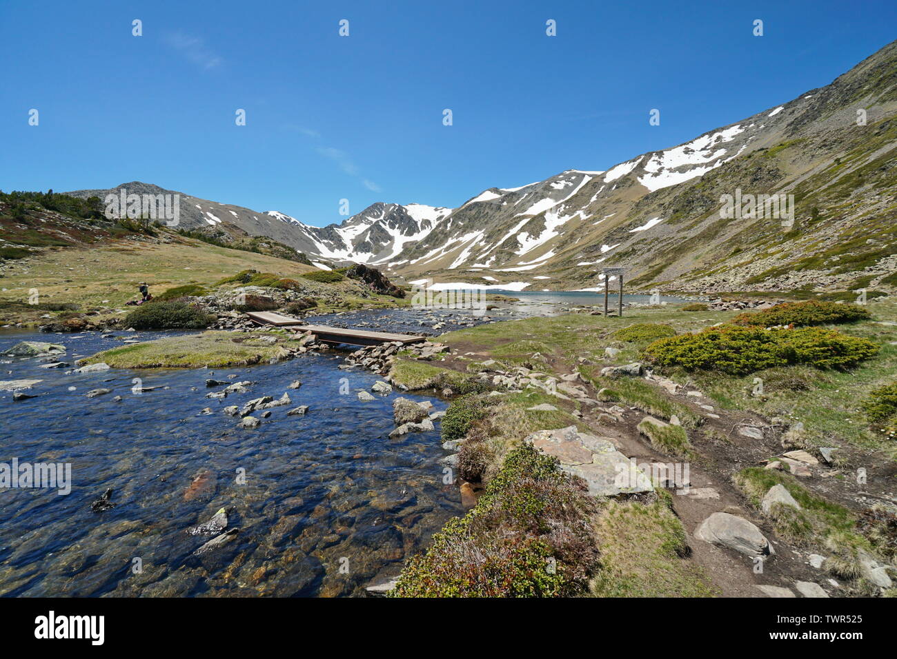 Francia Pirenei paesaggio di montagna, stream e Trebens lago con Carlit massiccio in background, parco naturale dei Pirenei catalani Foto Stock