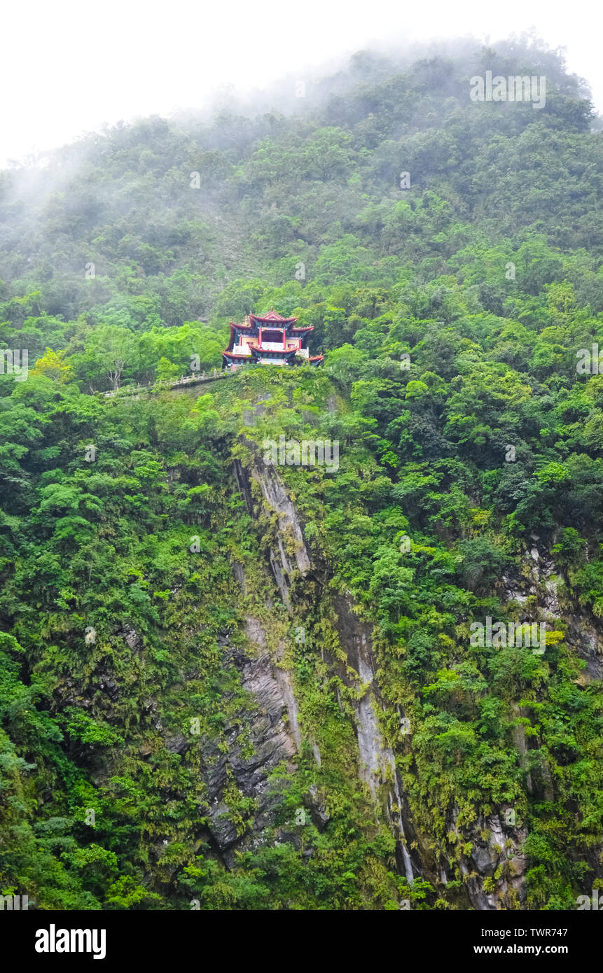 Incredibile tempio Taiwanese Taroko National Park. Il religioso santuario su una ripida roccia è circondato da verde tropical forest. Misty, foggy meteo. Concetto. La bellezza dei luoghi. Viaggio in Cina. Foto Stock