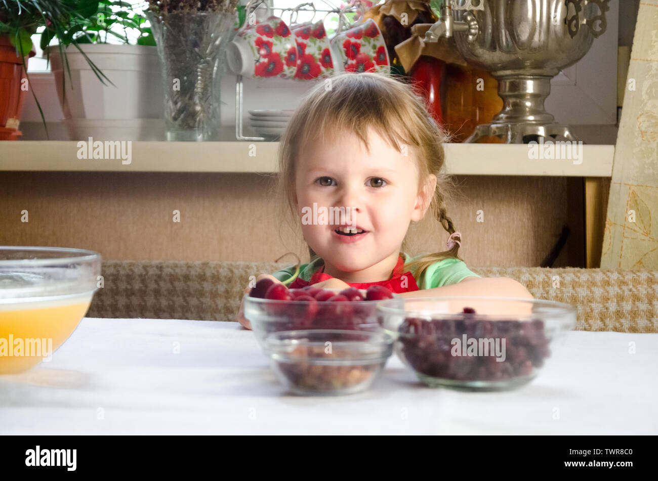 Ritratto di volti, mani felice nipote. curioso toddler girl gioca con la cottura, pasta di farina con cucina. bambino baby provare a studiare la cottura i cookie Foto Stock