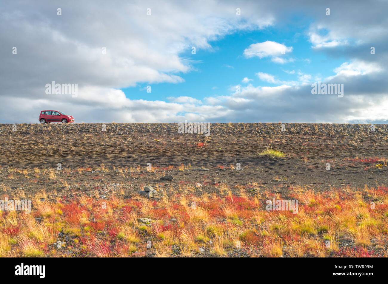 Rosso distanti Fiat Panda 4x4 parcheggiata su una strada di ghiaia fuori dal percorso battuto in Islanda. Auto commerciale foto di una piccola auto a noleggio durante un viaggio su strada. Foto Stock