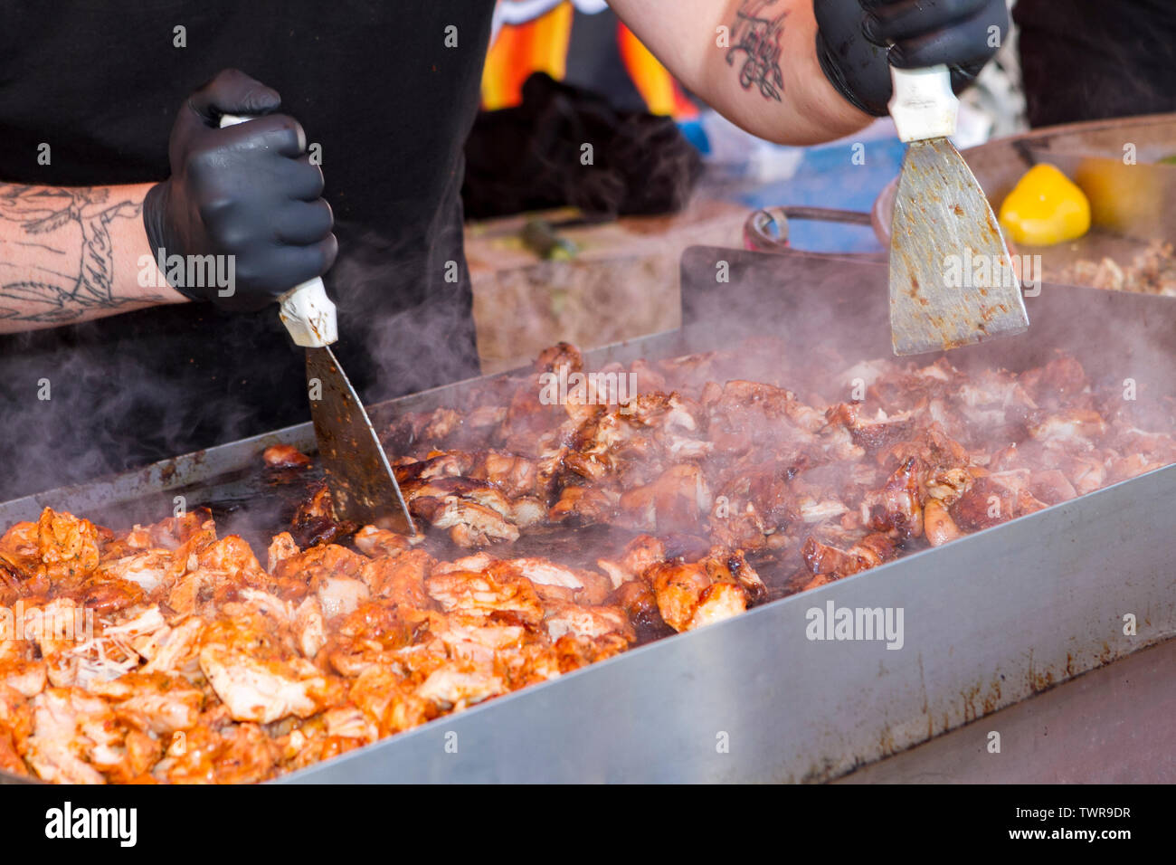 Un maschio di chef prepara barbecue cotto barbecue filetti di pollo Foto Stock