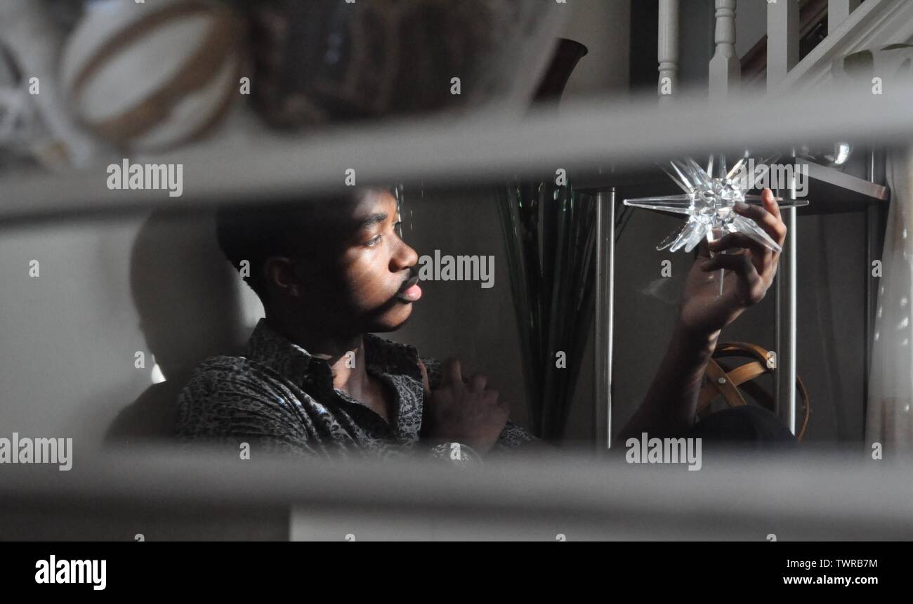 Specchio di riflessione giovane guardando un cristallo a riflessione Sfera decorativa Foto Stock