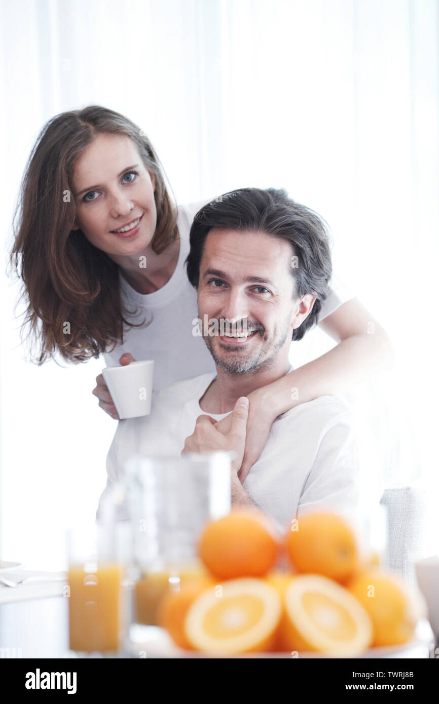 Paio di fare colazione insieme a casa , le arance e succo di frutta sul tavolo Foto Stock