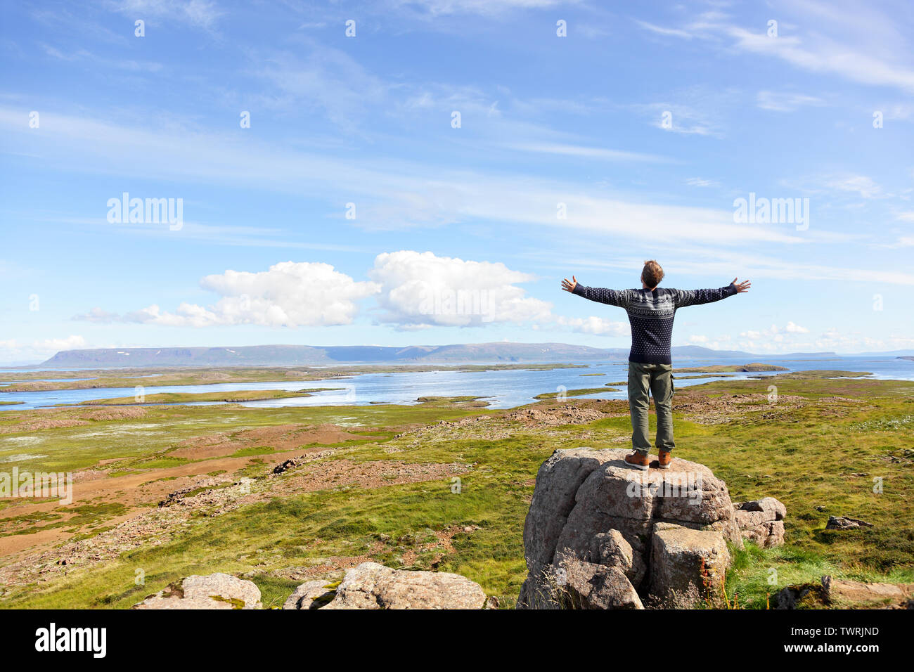 Libertà uomo nella natura in Islanda con bracci godendo libera la felicità nel bellissimo paesaggio islandese. Foto Stock