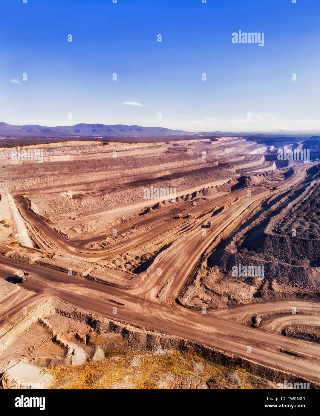Deep multi-layer aprire tagliare lo scavo di miniera di carbone nero per la masterizzazione a Liddell power station in alta Valle del Cacciatore di Australia. Autocarri pesanti materie in movimento Foto Stock
