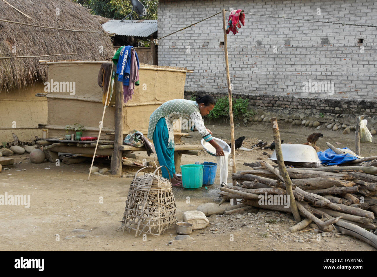 Donna di Tharu gruppo etnico che lavorano al di fuori la sua casa vicino a Chitwan, Nepal Foto Stock