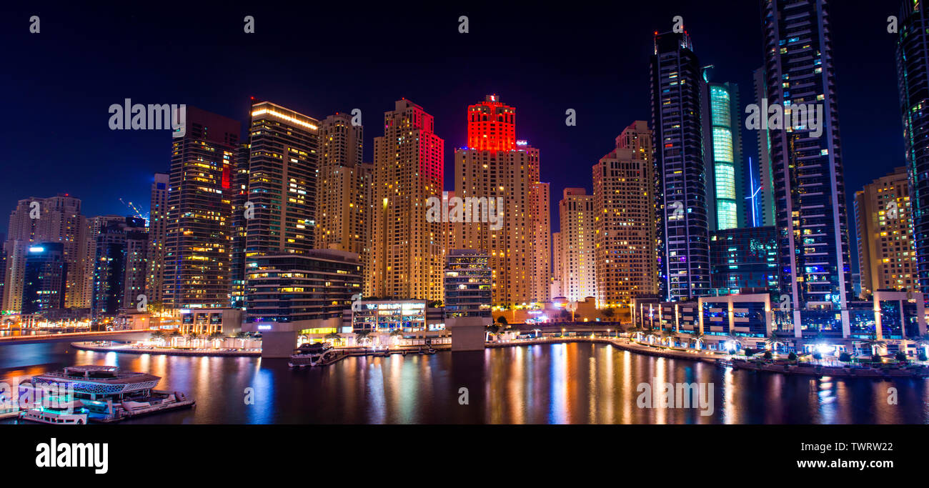 Colorata notte vista della citta' di Dubai Marina moderni edifici e lago in barca, yacht di lusso stile di vita incredibile architettura è il miglior posto per visitare il sito web Foto Stock