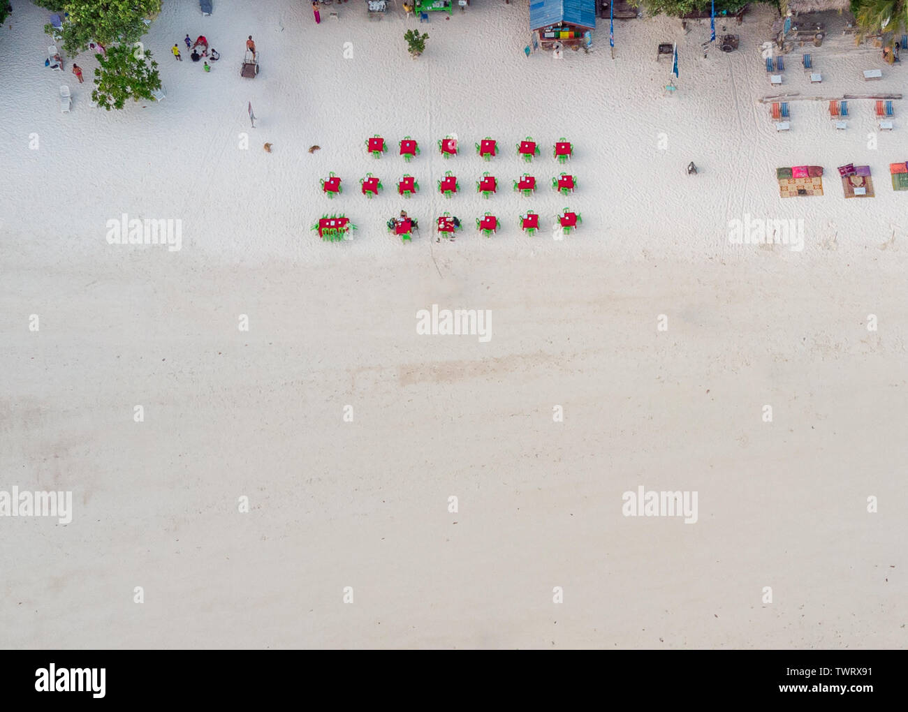 Vista superiore del rosso tavoli e sedie verde sulla bianca spiaggia presso il ristorante del resort Foto Stock
