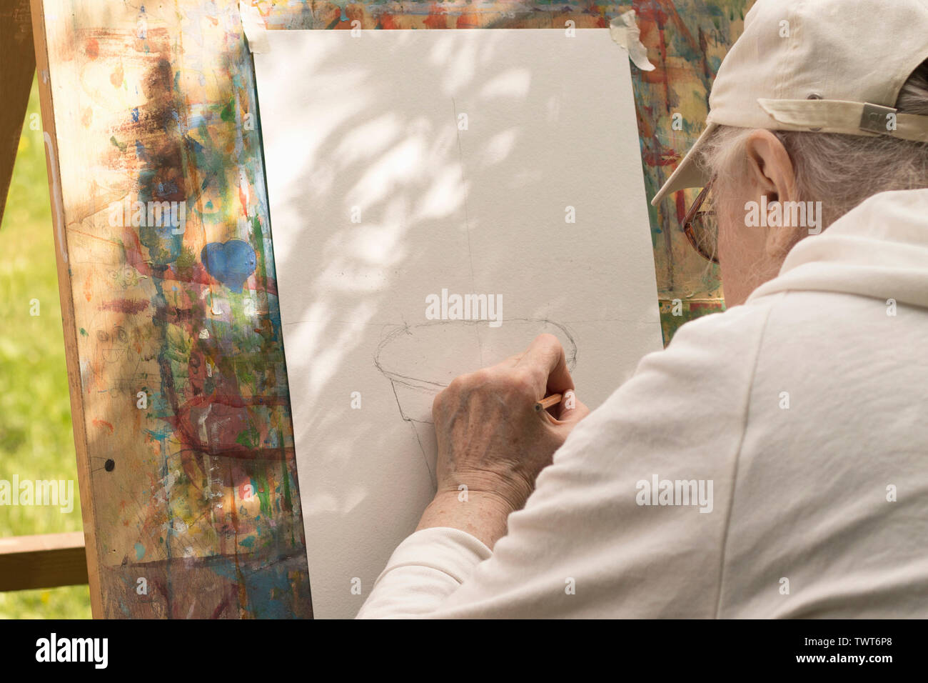 Senior grey-haired man Disegna con la mano sinistra a art studio per persone anziane. Mosca - 1 giugno 2019 Foto Stock