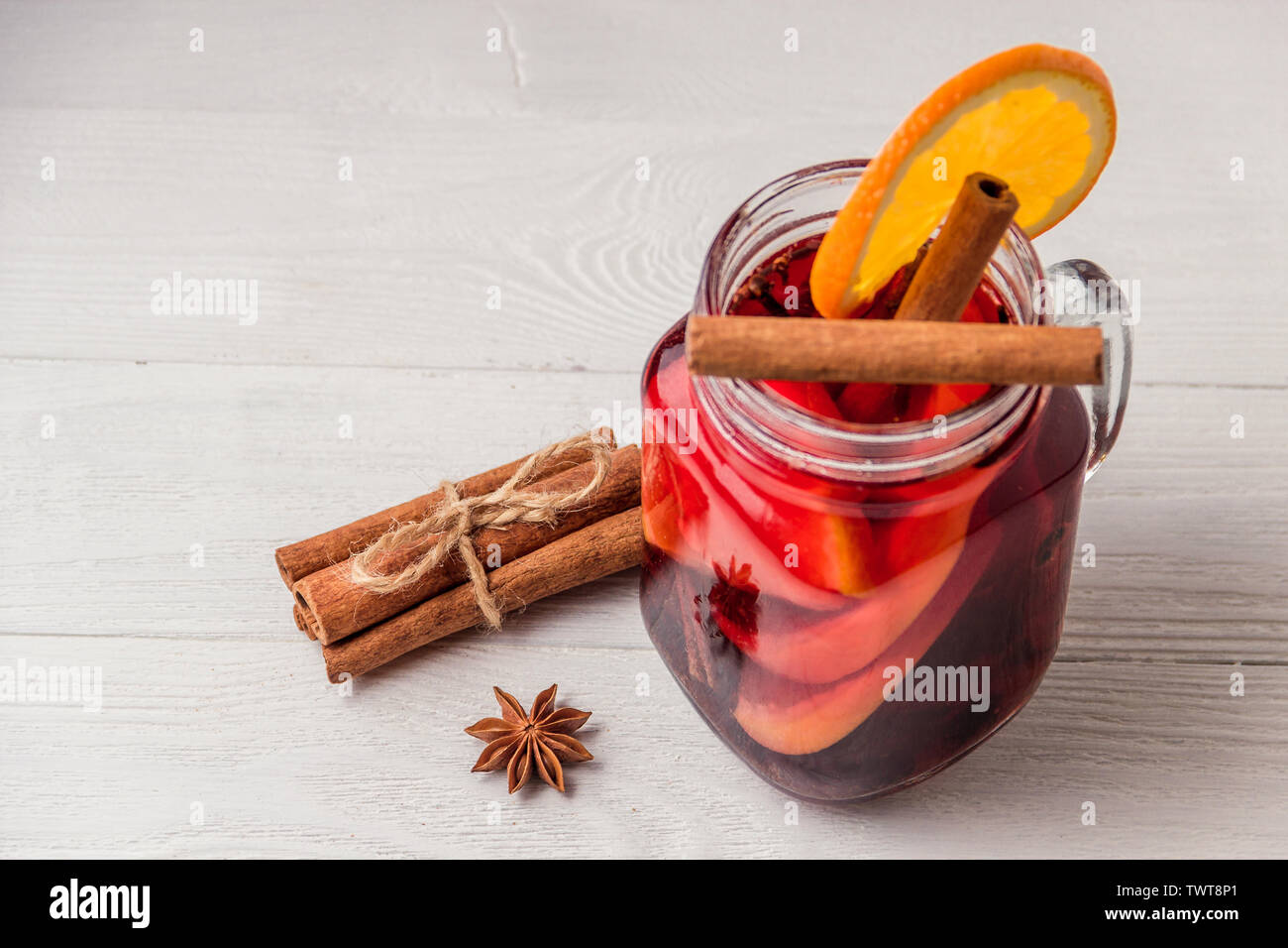 Vin brulé e spezie in bianco sullo sfondo di legno. Messa a fuoco selettiva Foto Stock