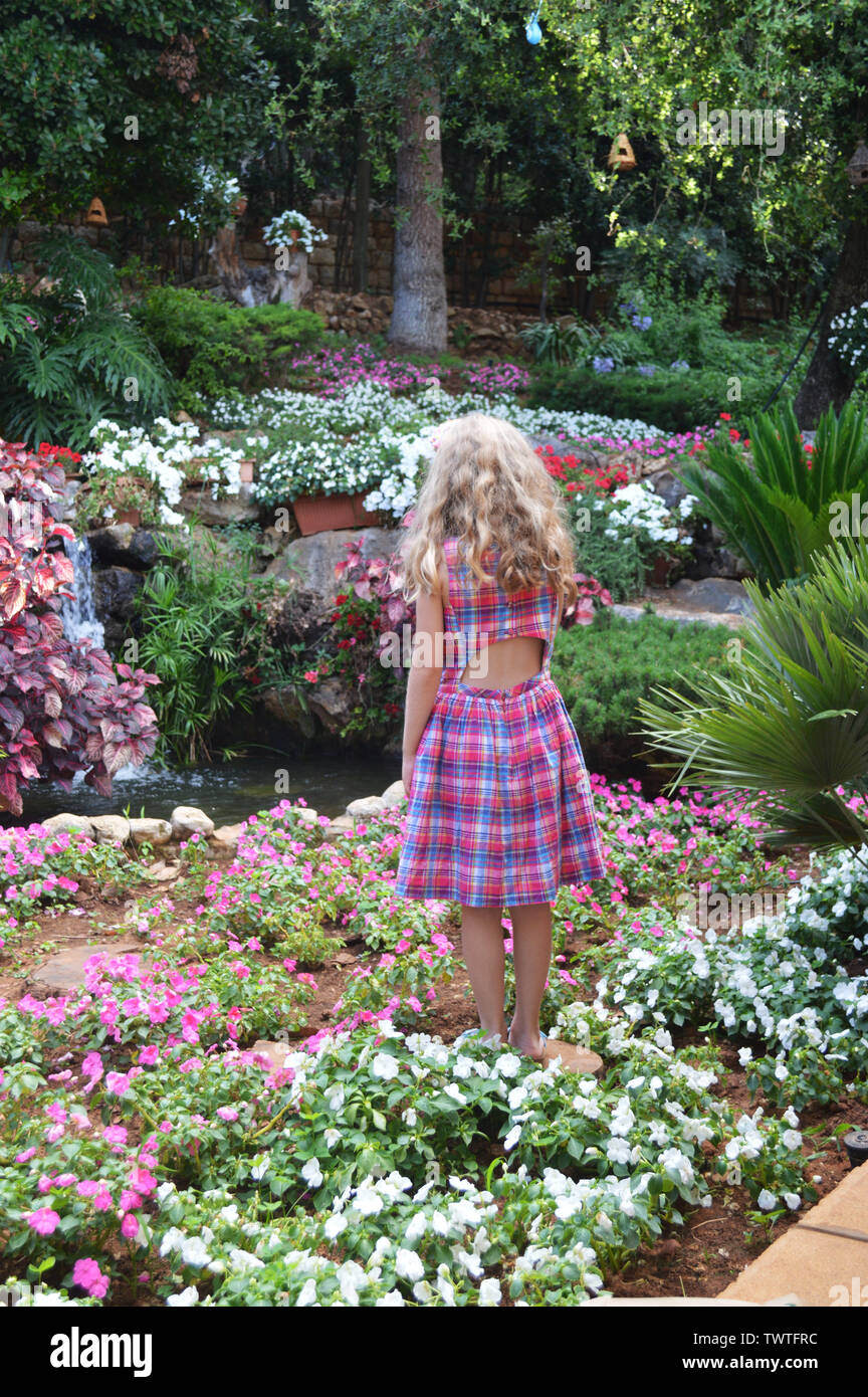 Una bionda bella ragazza guardando i fiori a Beirut, Libano Foto Stock