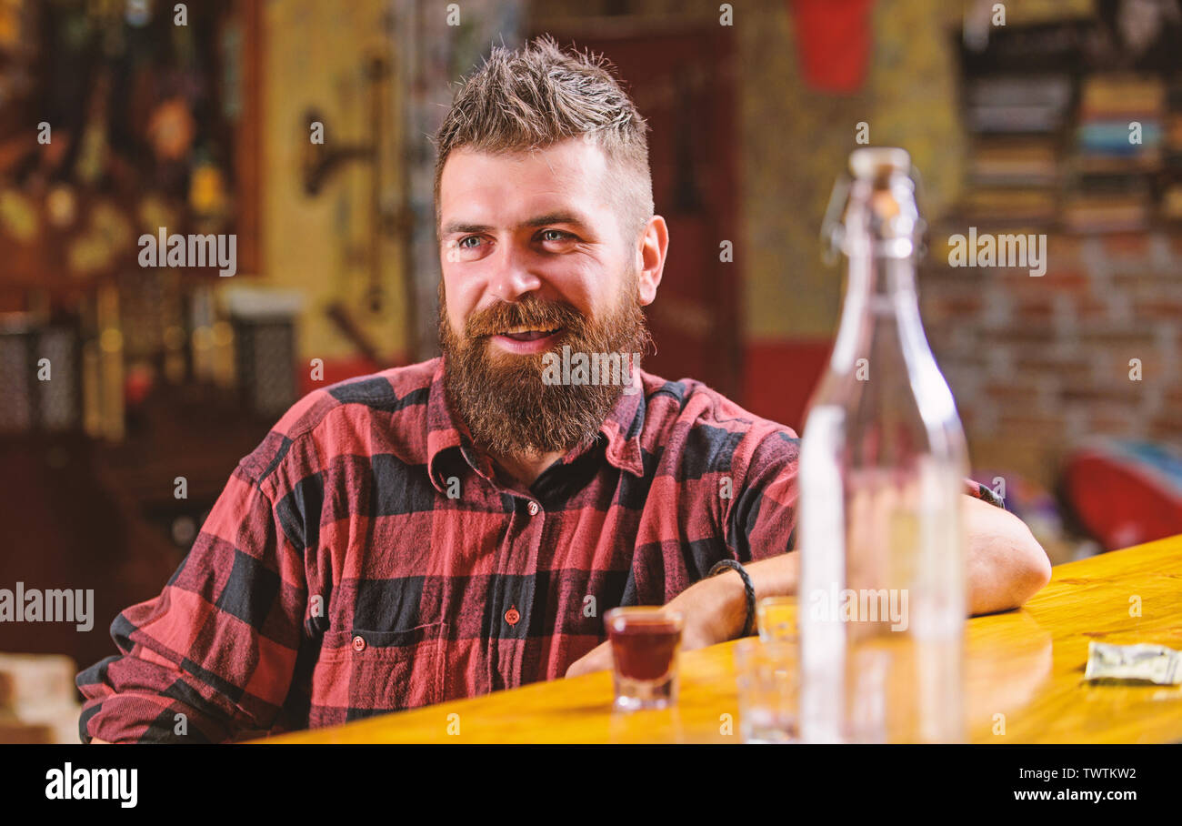 Hipster rilassante presso il bar. Bar rilassante per avere bere e rilassarsi. Uomo con barba trascorrere il tempo libero a bere alcol forte. Bere per divertimento. Brutale parigamba uomo barbuto sedersi al banco bar. Venerdì sera. Foto Stock