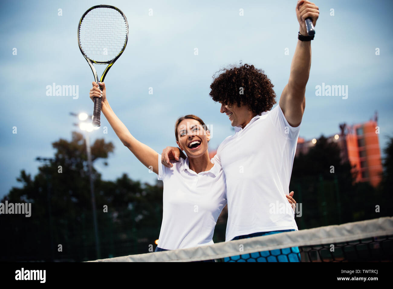 Coppia di giocatori di tennis sorridente alla corte dopo una partita Foto Stock