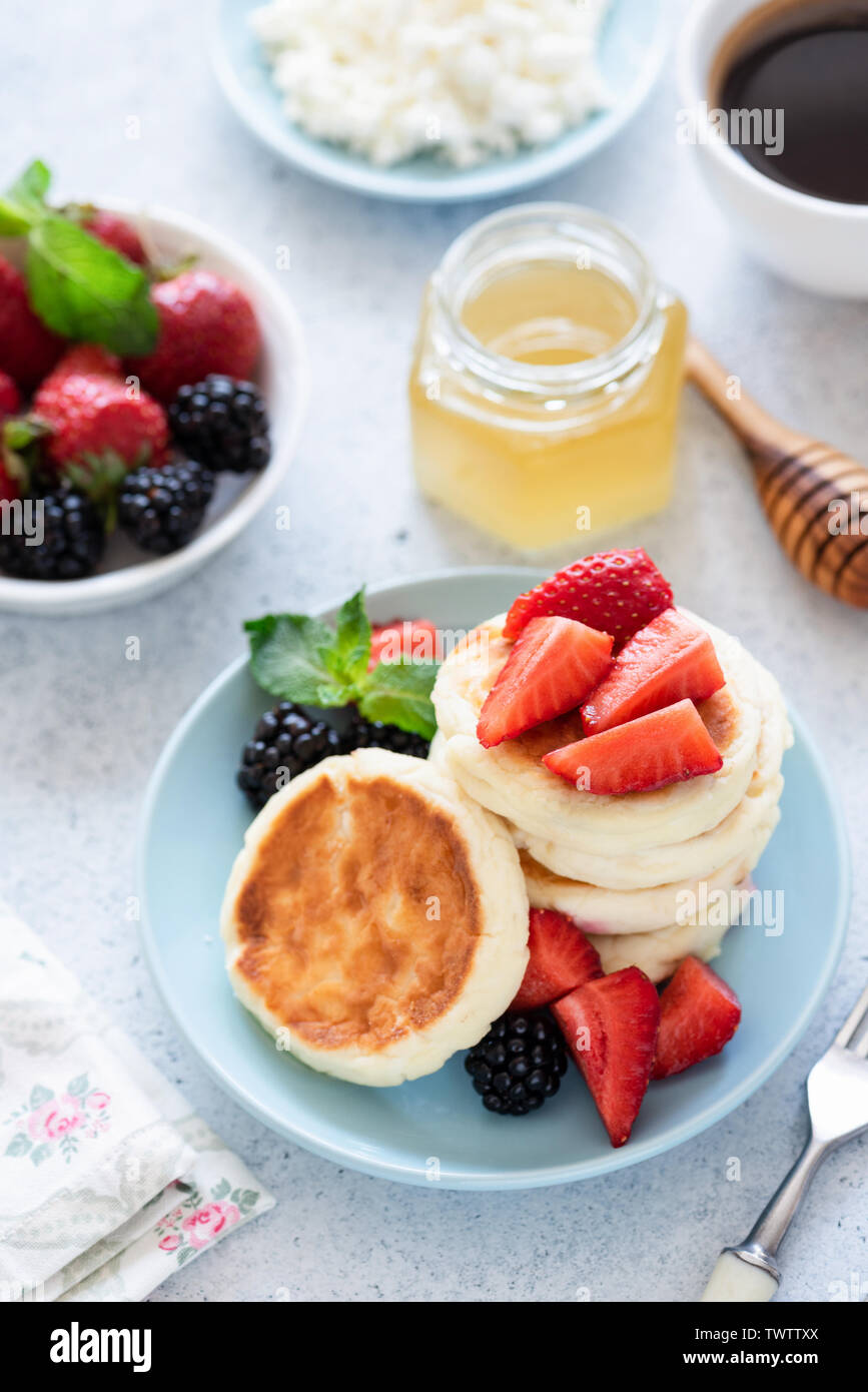 Cottage Cheese Pancakes, frittelle di cagliata, syrniki con miele e frutti di bosco Foto Stock