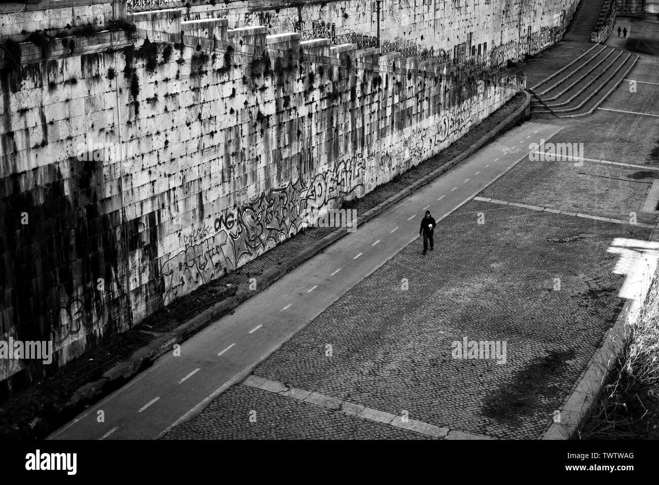 Lone uomo a camminare sul boulevard dal fiume Tevere a Roma Foto Stock