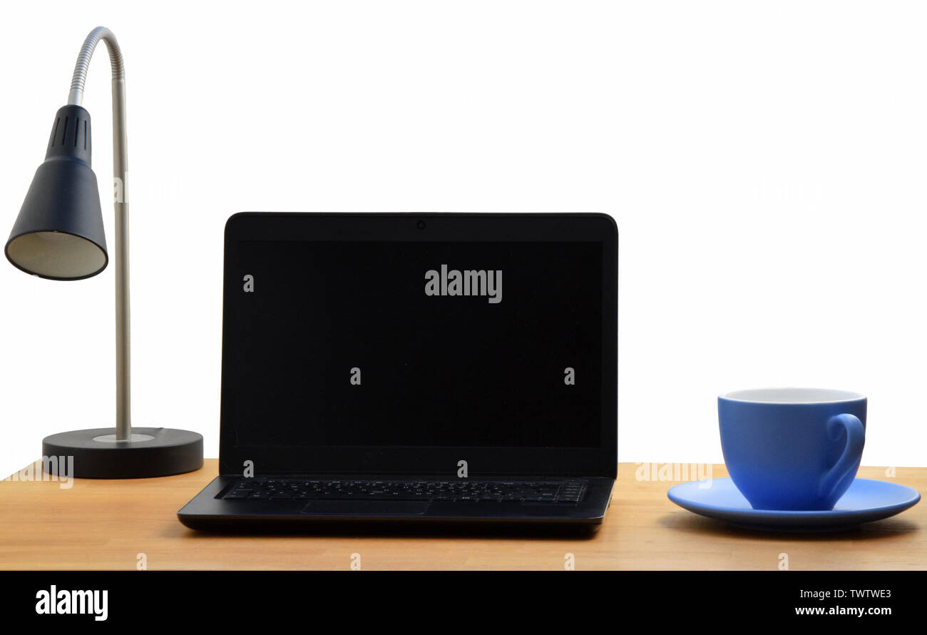 Home office con computer portatile, una lampada e una tazza di caffè Foto Stock