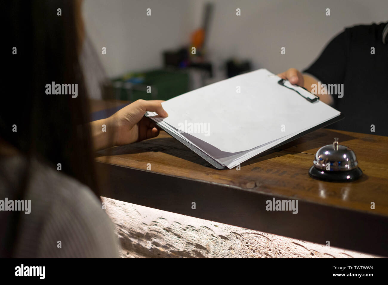 La receptionist ha inviato i documenti di valutazione per la firma e il riempimento forma processo di check-in.concetto di hotel. Foto Stock