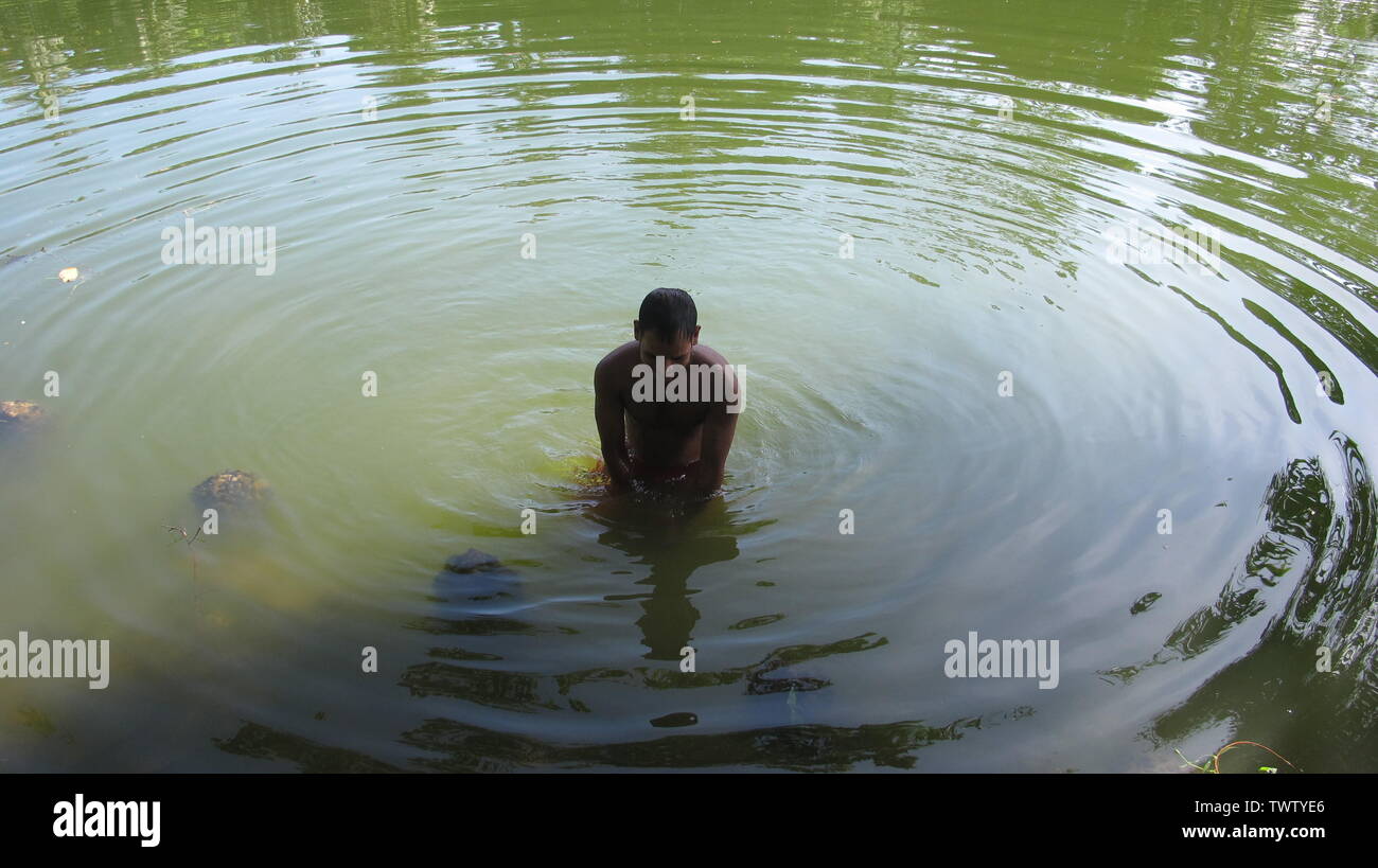 Estate ramna parco 23 giu,2019 Dhaka bangladesh.a uomo sta facendo un bagno nello stagno del parco ramana a causa di esaurimento del calore.Nazmul Islam / alamy stock vivere Foto Stock