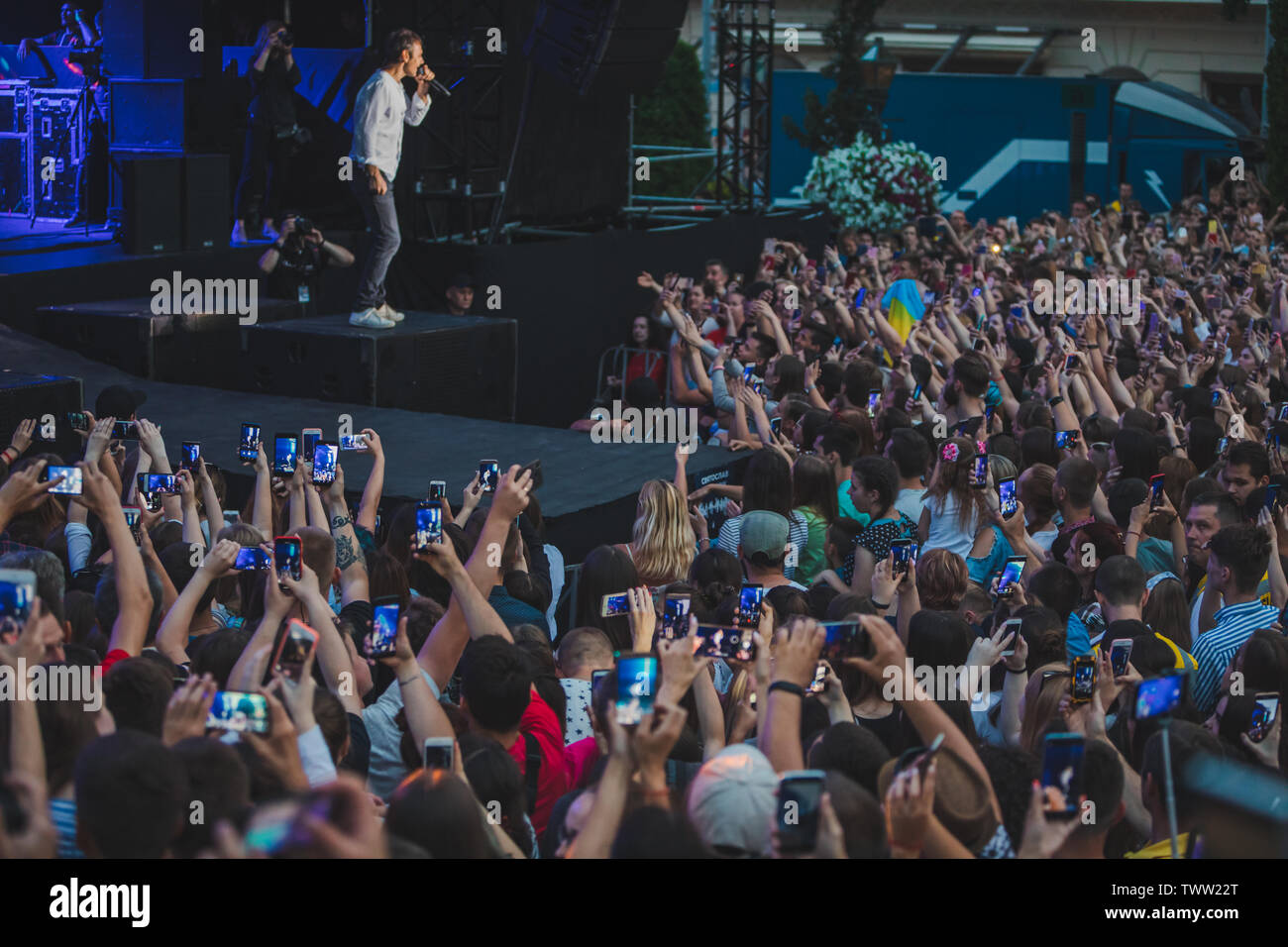 LVIV, Ucraina - 18 Giugno 2019: rock band cantante sul palco con microfono si affollano intorno Stadio riprese su telefoni. music fest Foto Stock