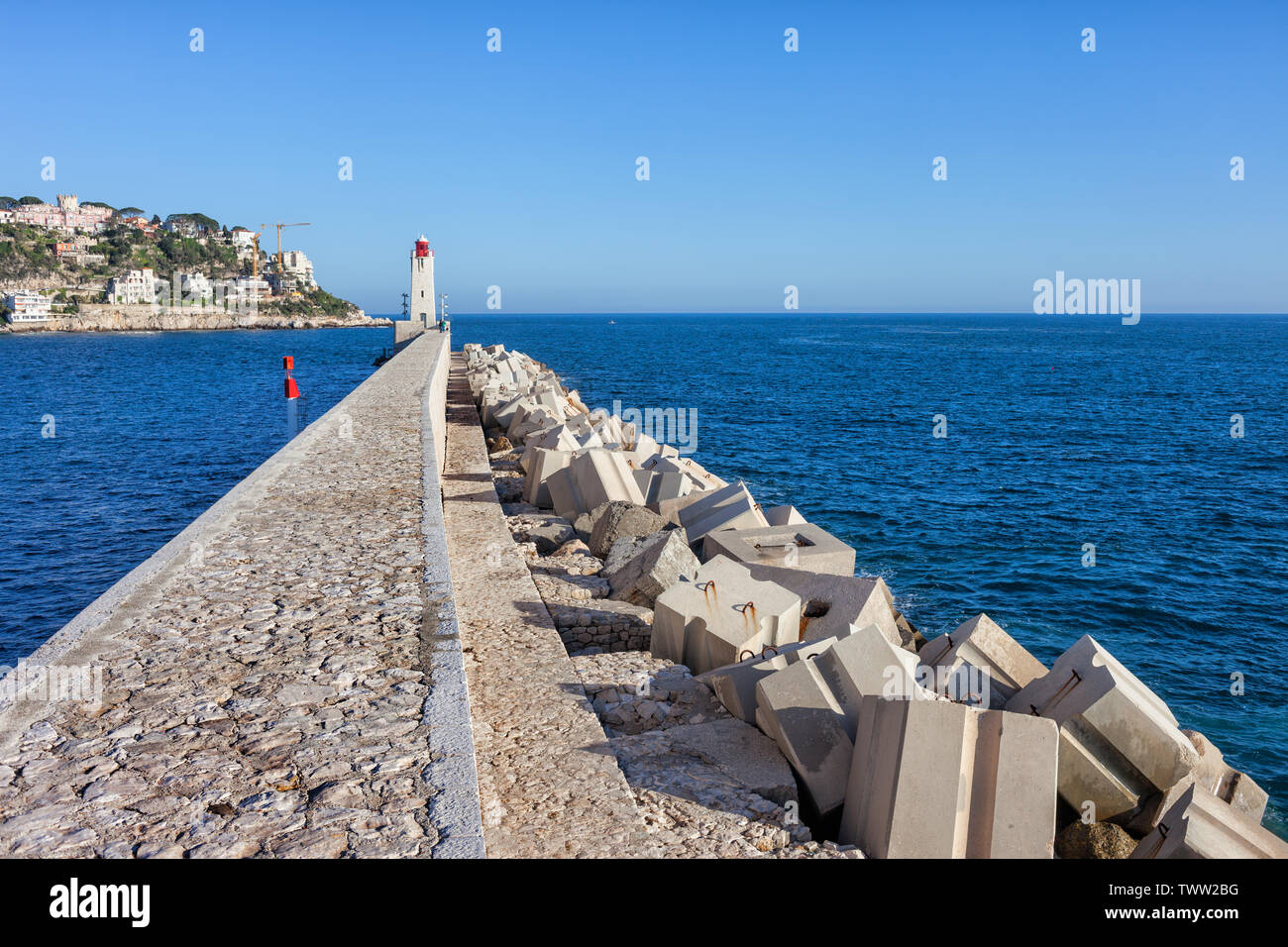 Francia, Nizza Cote d'Azur, molo sul mare con frangiflutti, Phare de Nice faro all'estremità lontana. Foto Stock