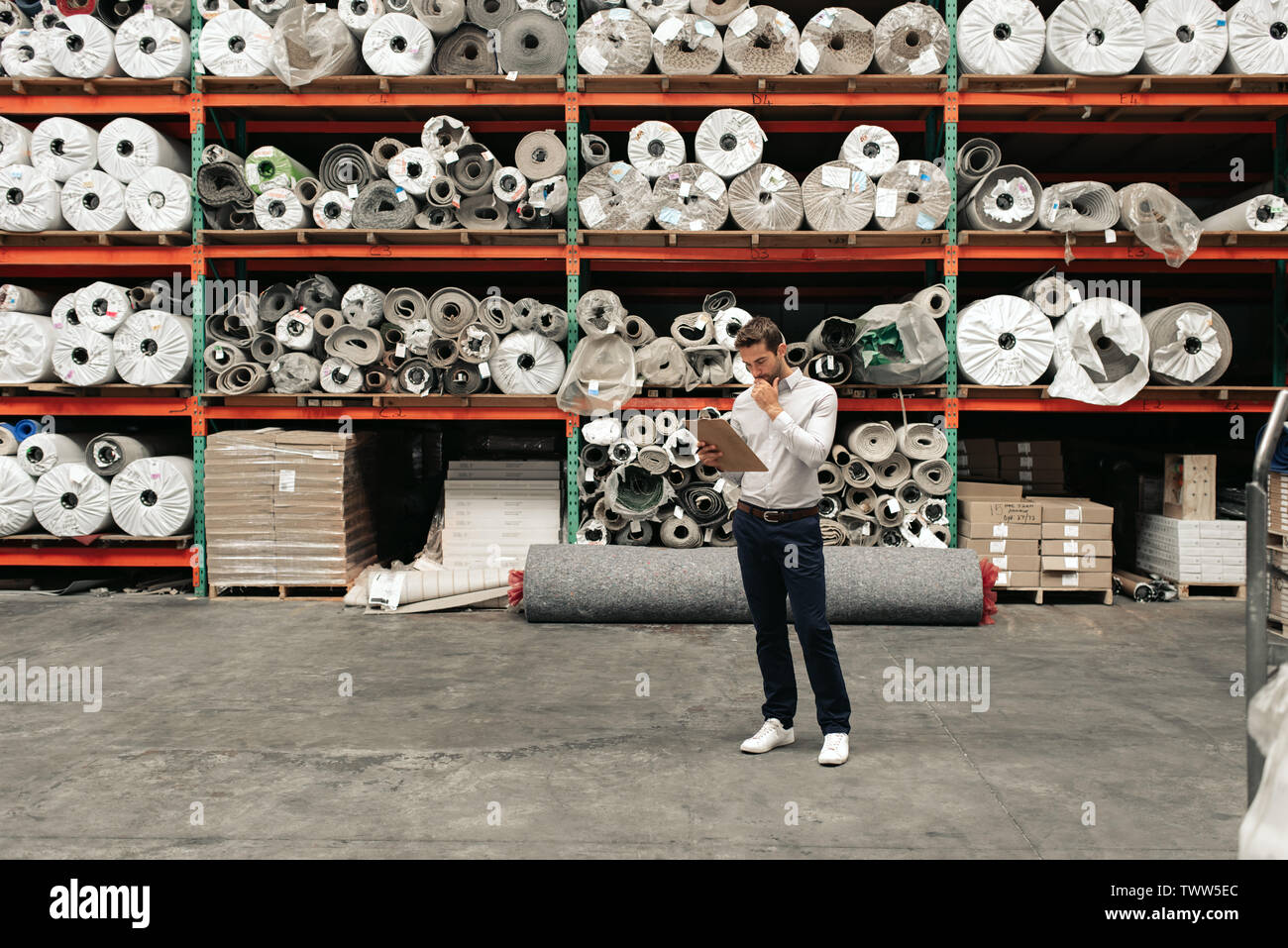 Responsabile di Magazzino utilizzando una clipboard mentre fa l'inventario Foto Stock
