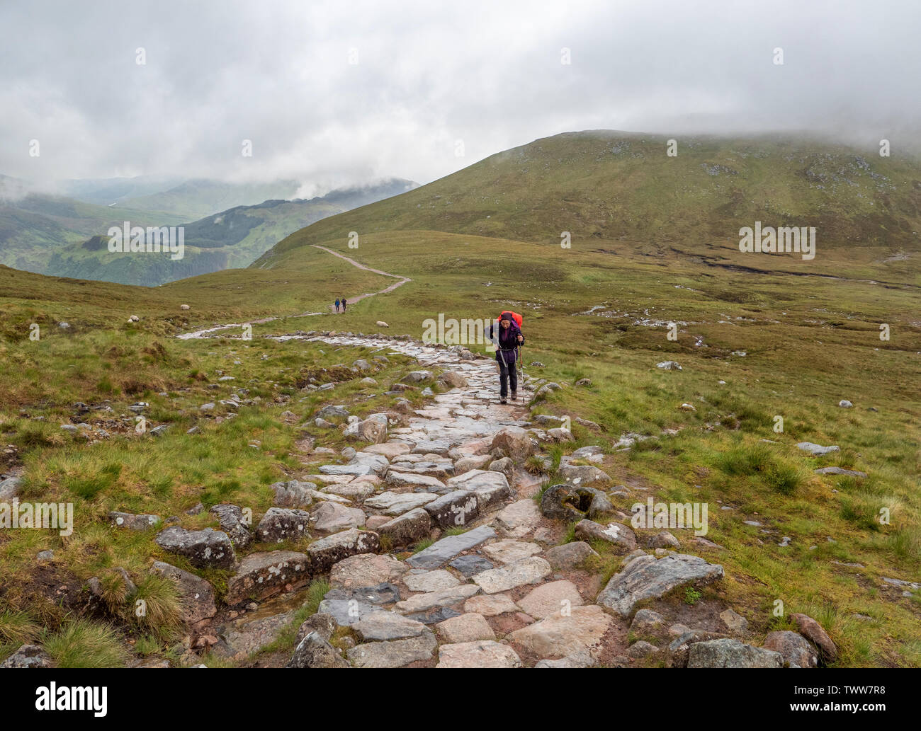 Walkers la salita ripida ma sentiero ben segnato per il vertice del Ben Nevis nelle Highlands della Scozia UK su un tipico giorno nuvoloso Foto Stock