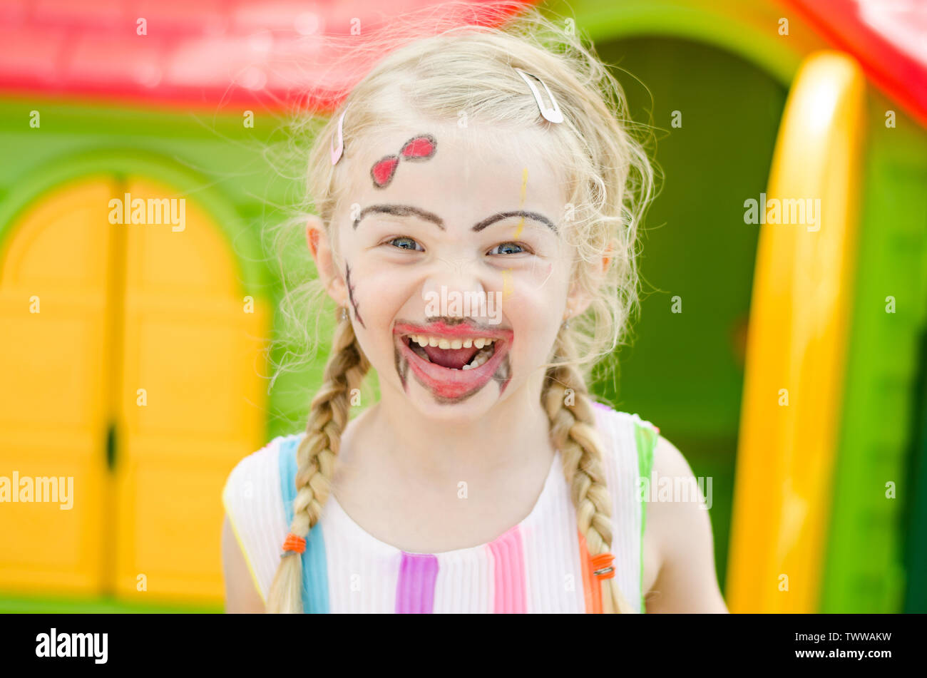 Felice "bella ragazza bionda con colorati facepainting Foto Stock