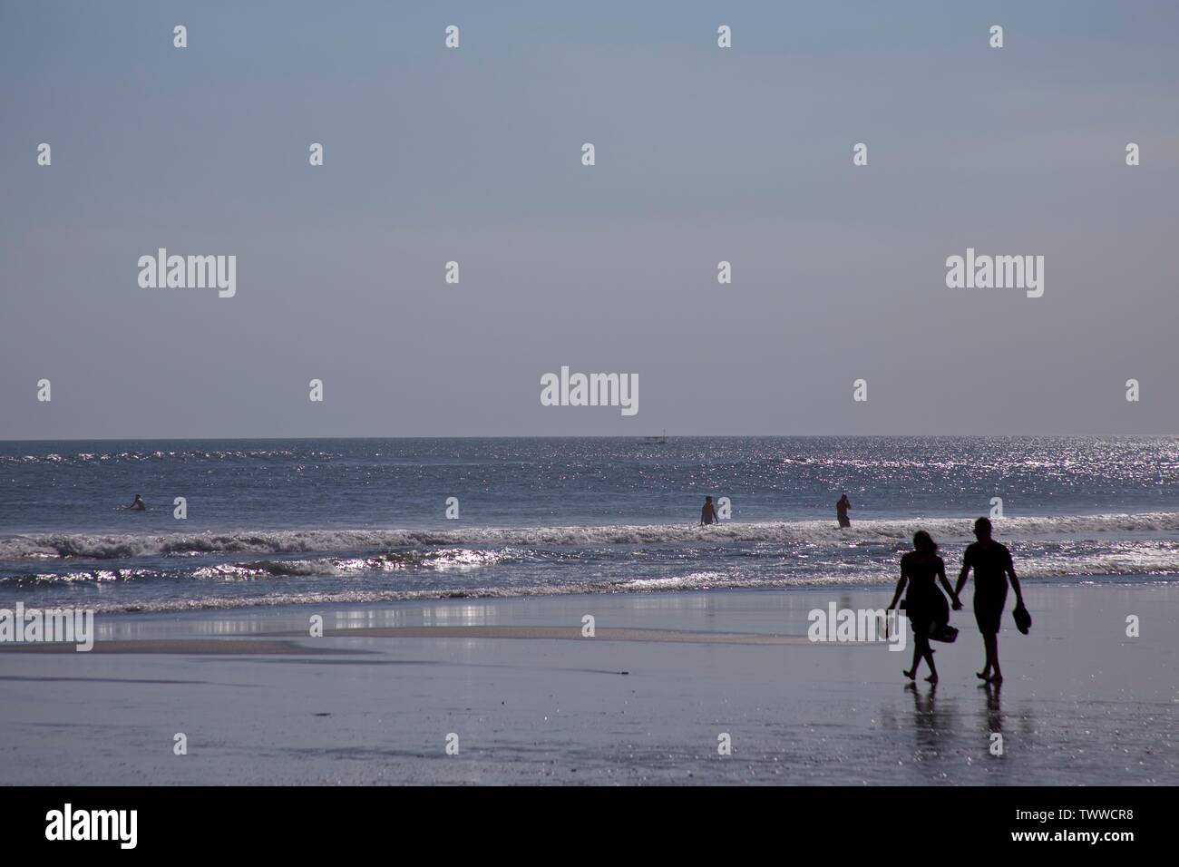 Paio di camminare su una spiaggia tenendo le mani Foto Stock