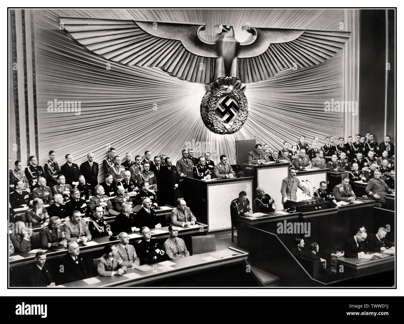 Adolf Hitler PODIO REICHSTAG DISCORSO Vintage pre-guerra 1930 Tedesco Propaganda nazista immagine del Cancelliere tedesco Adolf Hitler (permanente al leggio) offrendo un discorso al Reichstag sulla "questione ebraica", minacciando l'annientamento degli ebrei europei dovrebbero un' altra guerra break out, 30 gennaio 1939. Adolf Hitler - Führer e Reich Cancelliere della Germania e leader del partito nazista in Germania Foto Stock