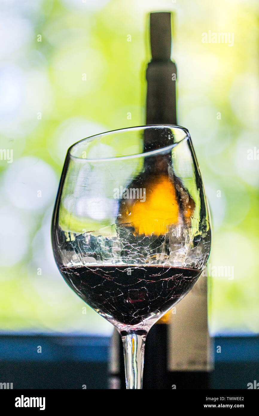 Una bottiglia di vino rosso dietro un bicchiere di vino rosso Foto Stock