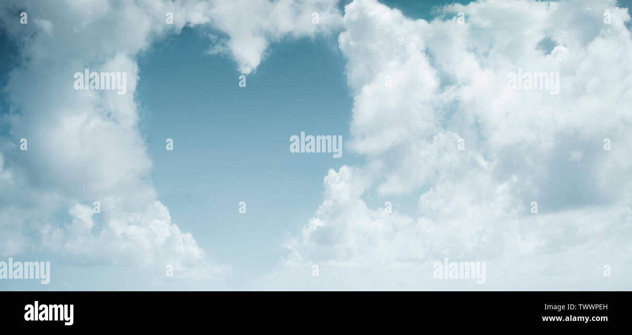 Bianco a forma di cuore nuvole su un cielo blu sullo sfondo Foto Stock