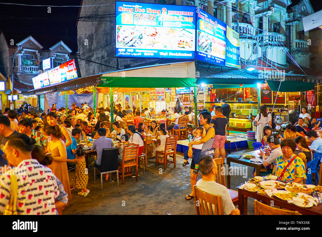 PATONG, Tailandia - 1 Maggio 2019: Le affollate food court di sera resort, le persone godono di cibo tailandese locale di ristoranti all'aperto, sedie e tavoli occupati Foto Stock