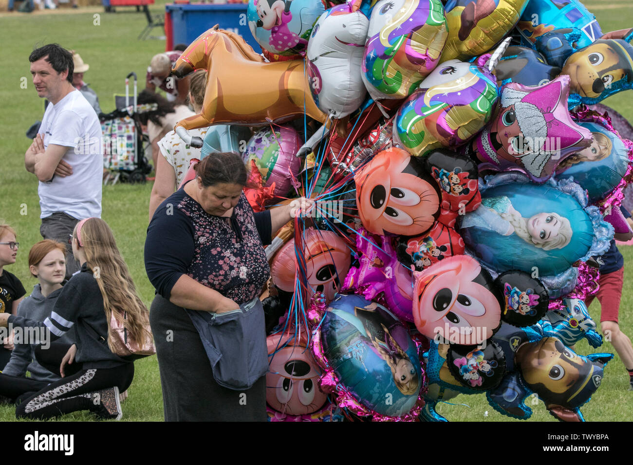Una donna vende palloncini gonfiabili di elio per bambini al festival musicale Africa Oye a Liverpool, Merseyside, Regno Unito Foto Stock
