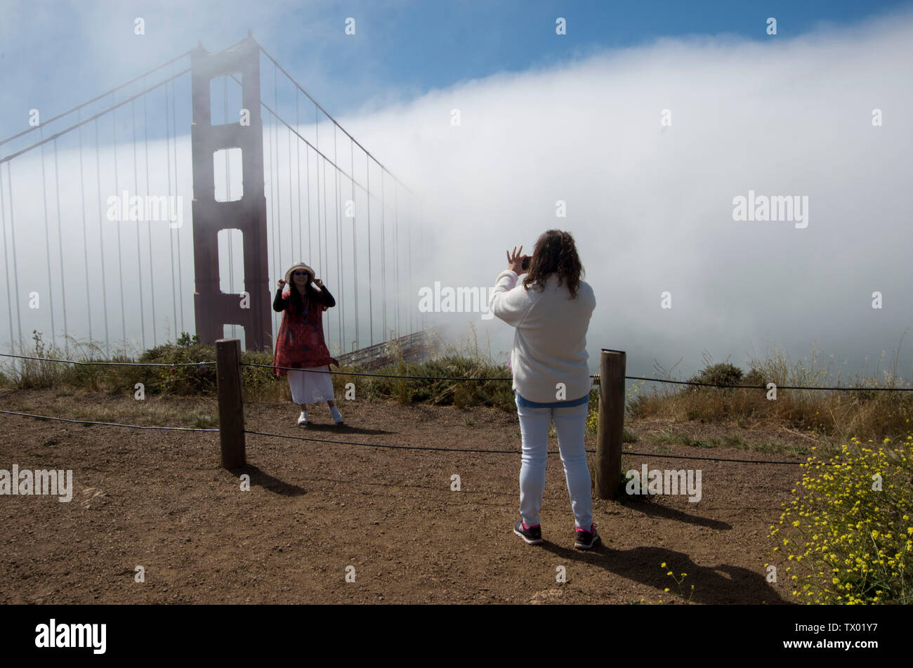 I turisti scattare foto del Golden Gate Bridge mentre è avvolto nella nebbia. Foto Stock