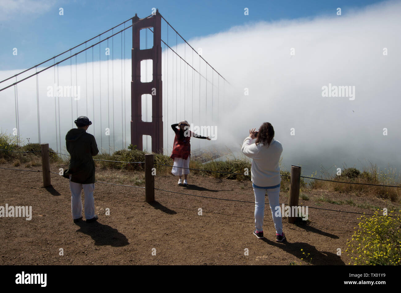 I turisti scattare foto del Golden Gate Bridge mentre è avvolto nella nebbia. Foto Stock