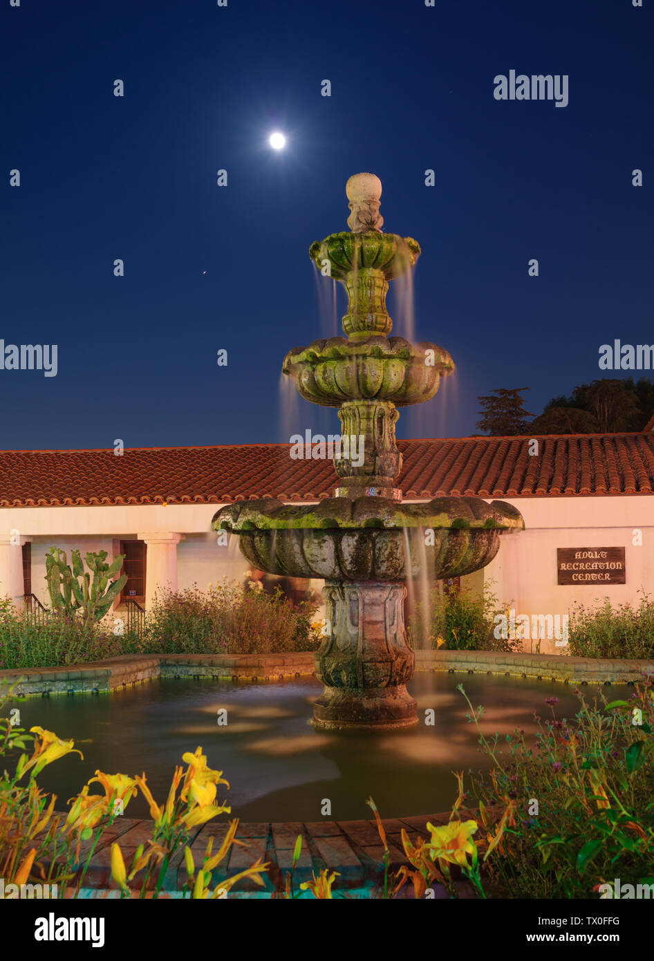Immagine che mostra la luna piena sorgere palese la costituzione Fontana al San Gabriel missione Playhouse in California. Foto Stock