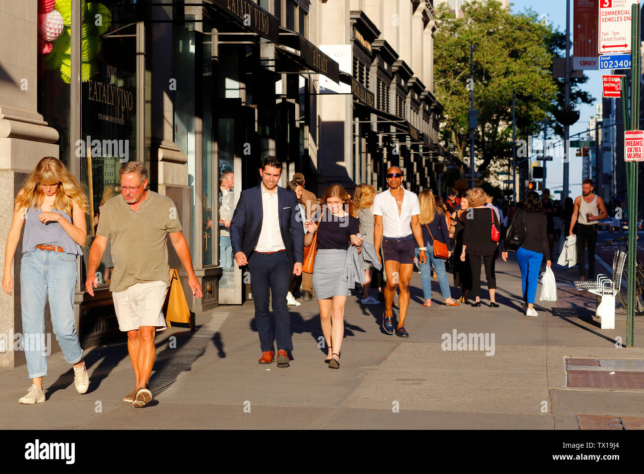 La gente cammina lungo la W 23rd St nel quartiere Flatiron di Manhattan, New York City in un caldo pomeriggio estivo sul solstizio estivo 21 giugno 2019 Foto Stock