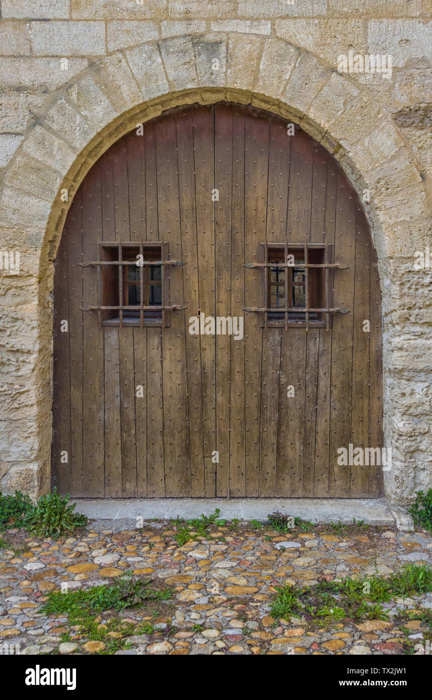 Vecchio arcuata porta in legno con finestre sbarrate Foto stock - Alamy