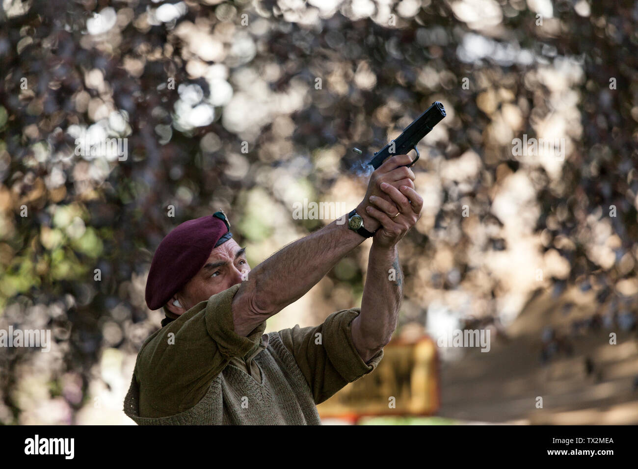 Ri-enactor scaricando una pistola con cartuccia espulsa a metà in aria, Barnard Castle, 1940's Weekend 2019, Teesdale, County Durham, Regno Unito. Foto Stock
