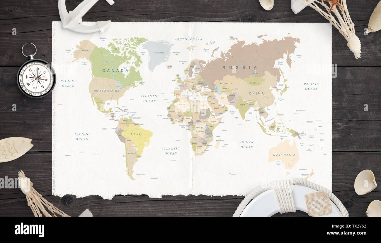 Mappa del mondo sulla carta vecchia circondata dalla bussola di ancoraggio, lifebelt e conchiglie. Foto Stock