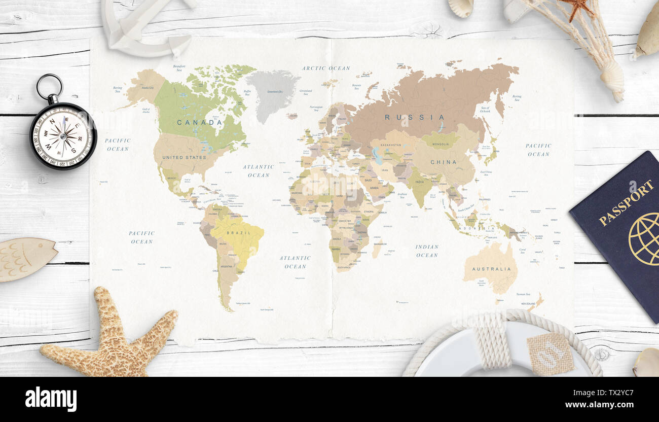 Mappa del mondo, bussola, passaporto e conchiglie. Concetto di pianificazione del viaggio. Vista dall'alto. Bianco scrivania in legno. Foto Stock