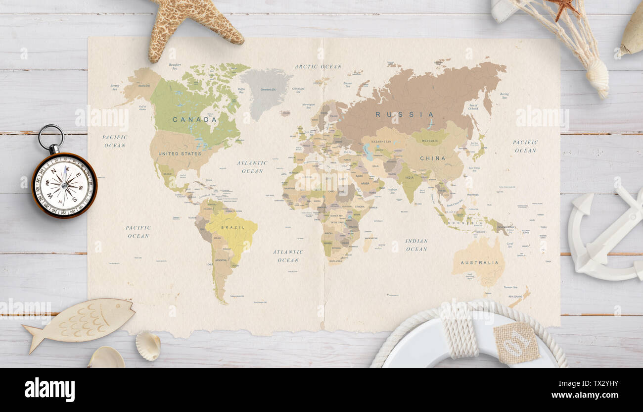 Mappa del mondo su un tavolo circondato da gusci, bussola di ancoraggio, e lifebelt. Il concetto di pianificazione delle vacanze in paesi lontani. Foto Stock