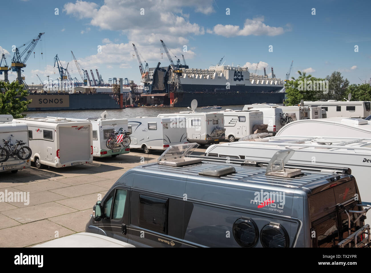 Parcheggio auto con camper e caravan a fianco di Docklands e area del porto e del fiume Norderelbe, Amburgo, Germania Foto Stock