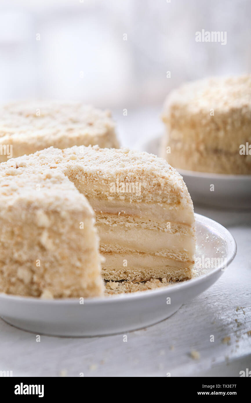 Torta Napoleone sulla piastra bianca. Cucina russa, multistrato torta con crema pasticcera Foto Stock