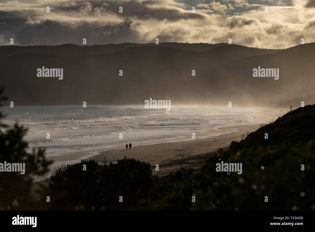 Silhouette giovane camminando sulla tranquilla spiaggia di tramonto, Ingresso Aireys, Victoria, Australia Foto Stock